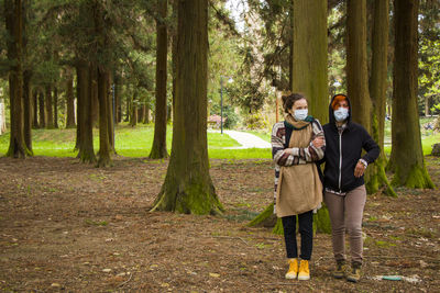 Two women friends in the park with face masks