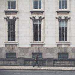 Side view of woman standing against building