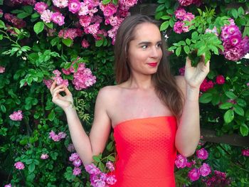 Young woman looking at flowers in park