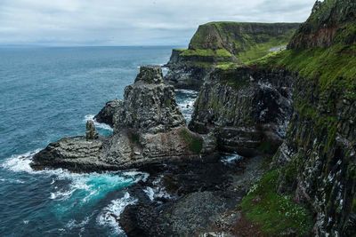 Rock formations by sea against sky