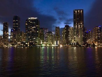 Illuminated buildings in city against sky at night