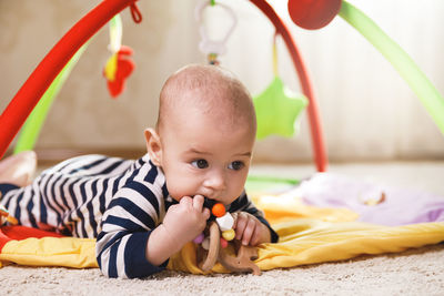 Portrait of cute baby girl lying on bed at home