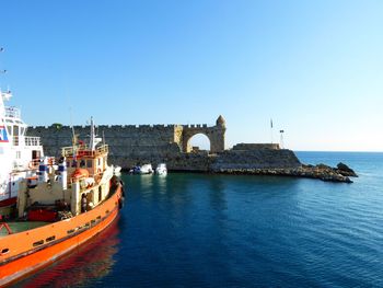 Boats in sea against clear sky