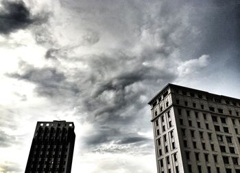 Low angle view of modern building against cloudy sky