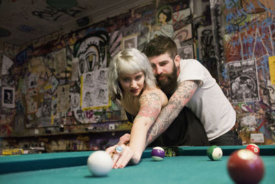 Young couple playing pool