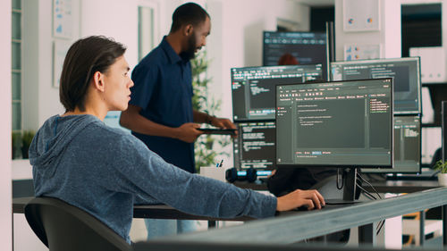 Side view of man using laptop at office