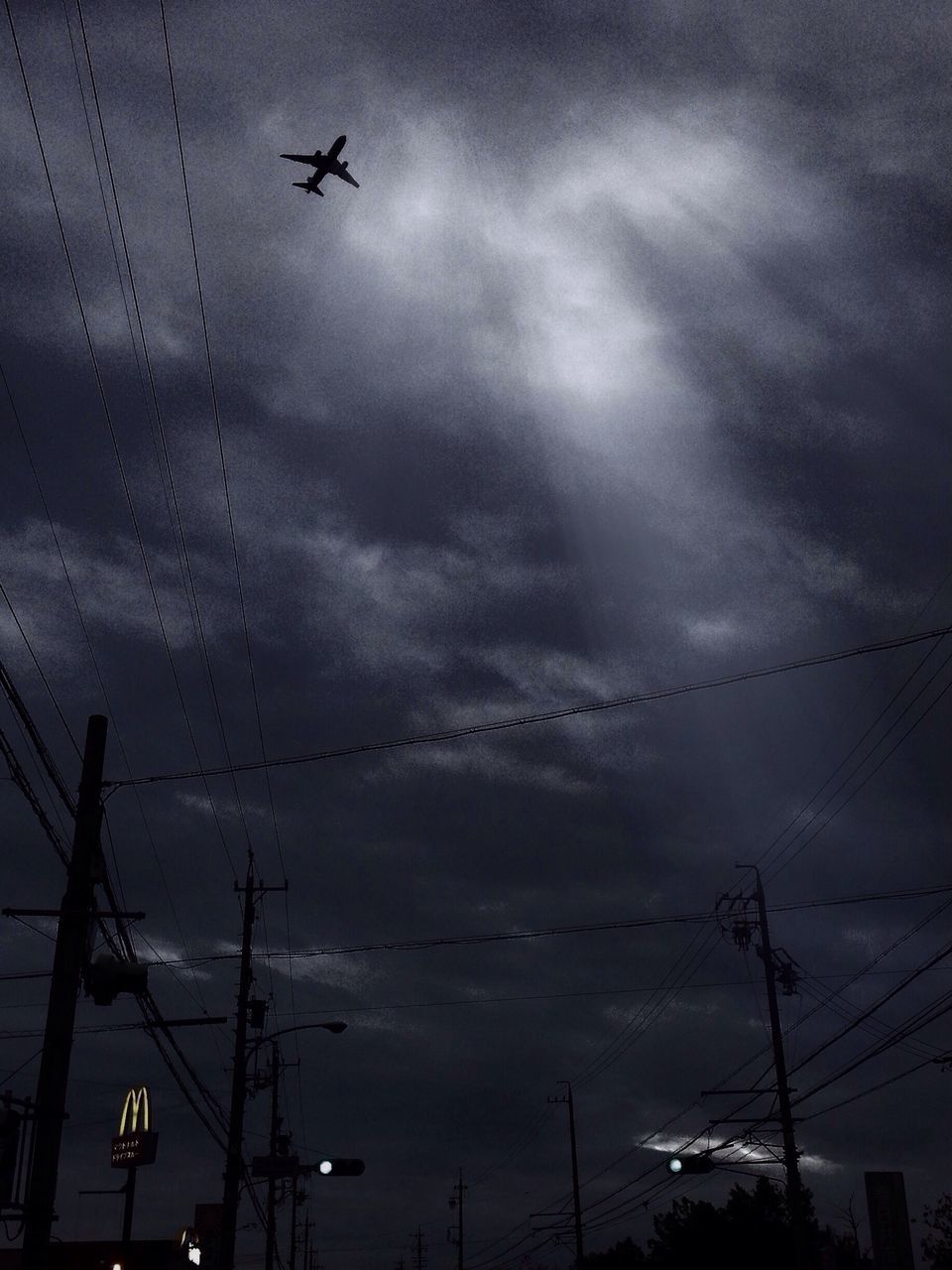 flying, sky, low angle view, power line, electricity, airplane, silhouette, cloud - sky, transportation, electricity pylon, bird, fuel and power generation, connection, mode of transport, technology, air vehicle, cable, power supply, cloudy, dusk