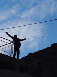 Low angle view of woman standing against sky