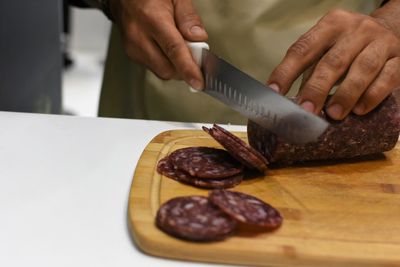 Midsection of person preparing food on cutting board