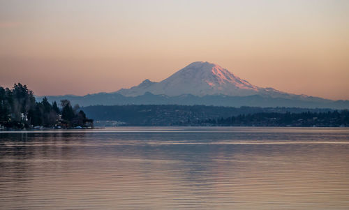 Scenic view of lake and mountains against sky during sunset