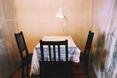 Empty chairs and table against wall at home