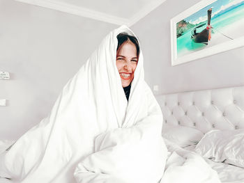 Portrait of smiling young woman on bed