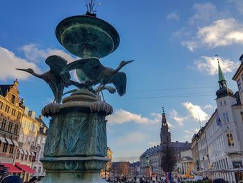 Low angle view of statue against buildings in city