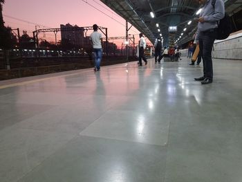 Rear view of people walking in illuminated city