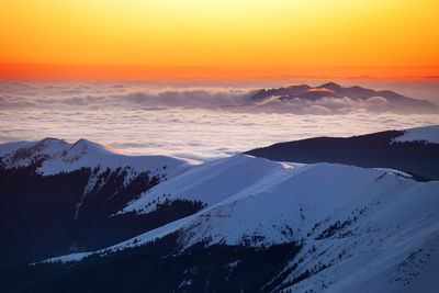 Scenic view of snow covered mountains during sunset