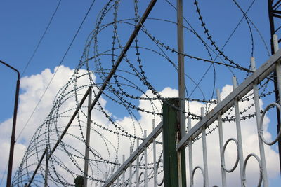 Low angle view of barbed wire against sky