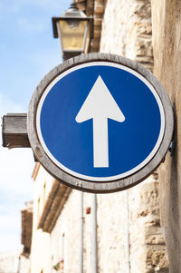 Low angle view of road sign against blue sky