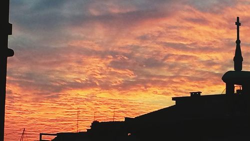 Silhouette buildings against sky during sunset