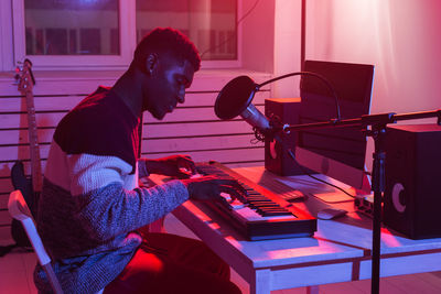 Rear view of woman playing piano