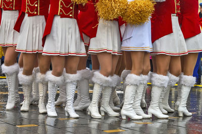 Low section of cheerleaders standing at footpath