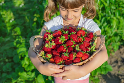 Cute girl with basket of strawberries