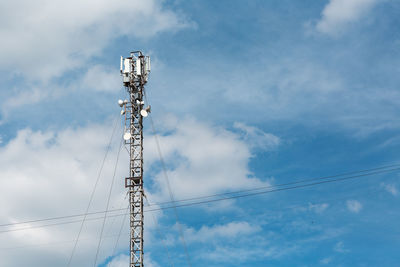 Low angle view of communications tower against blue sky