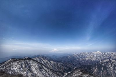 Scenic view of snowcapped mountains against blue sky at night