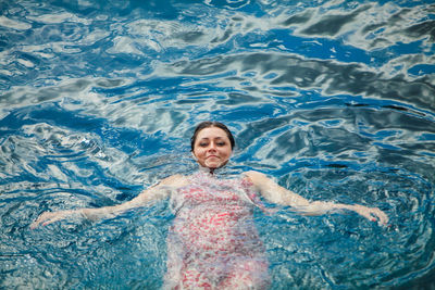 Portrait of a smiling woman swimming in pool