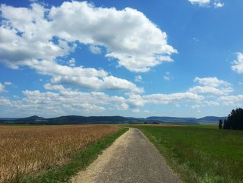 Dirt road passing through field