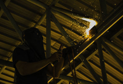 Low angle view of man welding in factory