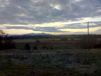 Scenic view of field against sky at sunset