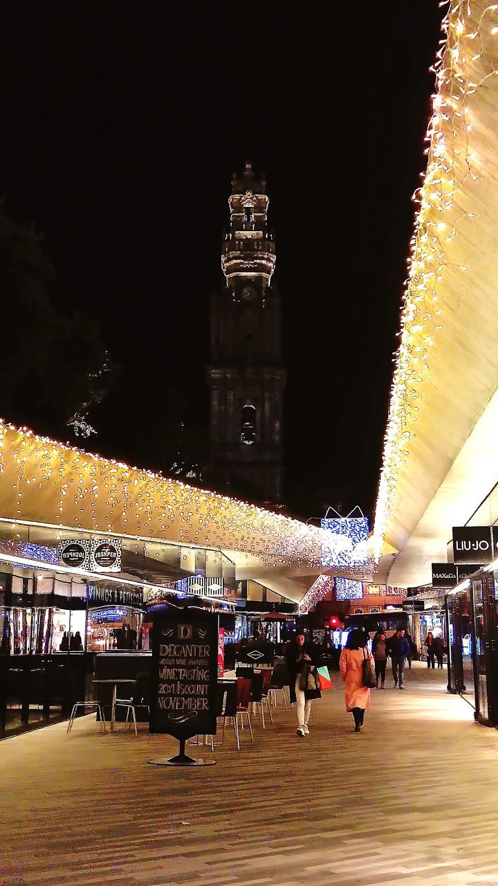 PEOPLE ON ILLUMINATED STREET LIGHTS AT NIGHT