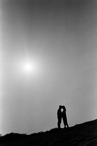 Silhouette man standing on field against sky