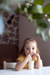 Portrait of cute baby boy sitting on bed at home