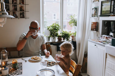 Rear view of man eating food