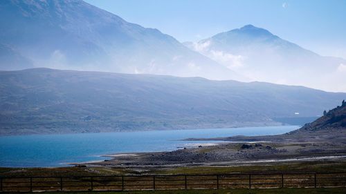 Scenic view of sea and mountains against sky