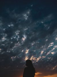 Rear view of silhouette woman against sky during sunset