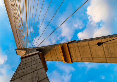 Low angle view of bridge against cloudy sky