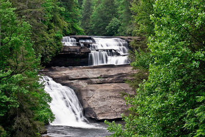 Waterfall over rocks amidst trees