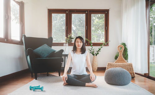 Portrait of woman sitting on floor at home