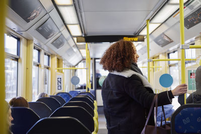 Young woman standing in bus