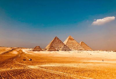 Pyramids at desert against blue sky