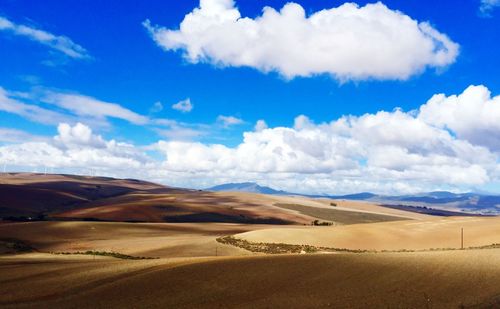 Scenic view of desert against blue sky