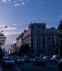 Traffic on city street against blue sky