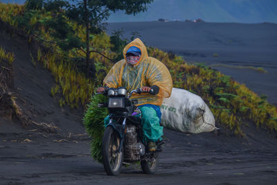 View of man riding motorcycle on road bromo mountain