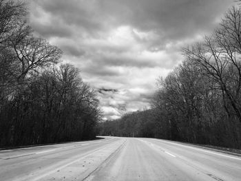 Country road against cloudy sky