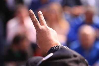 Close-up of cropped hand showing peace sign