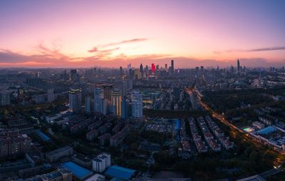 Aerial view of modern buildings against sky during sunset