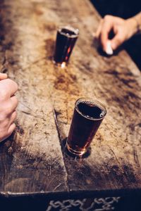 Midsection of person holding drink on table