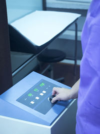 Close-up midsection of doctor adjusting medical equipment in hospital